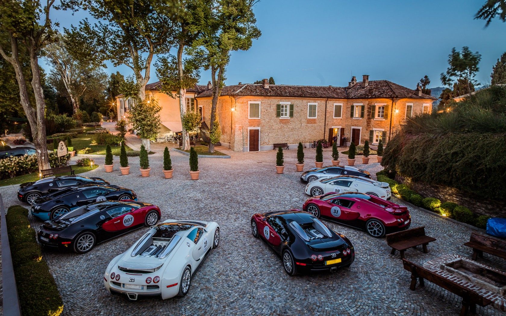 Row of exotic supercars in front of luxury property